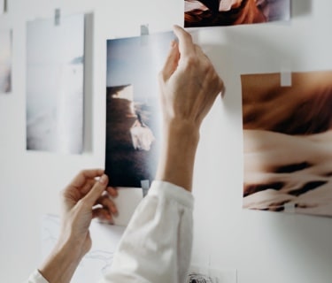 woman taping documents on a wall