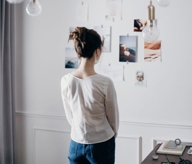 woman looking at documents taped on a wall